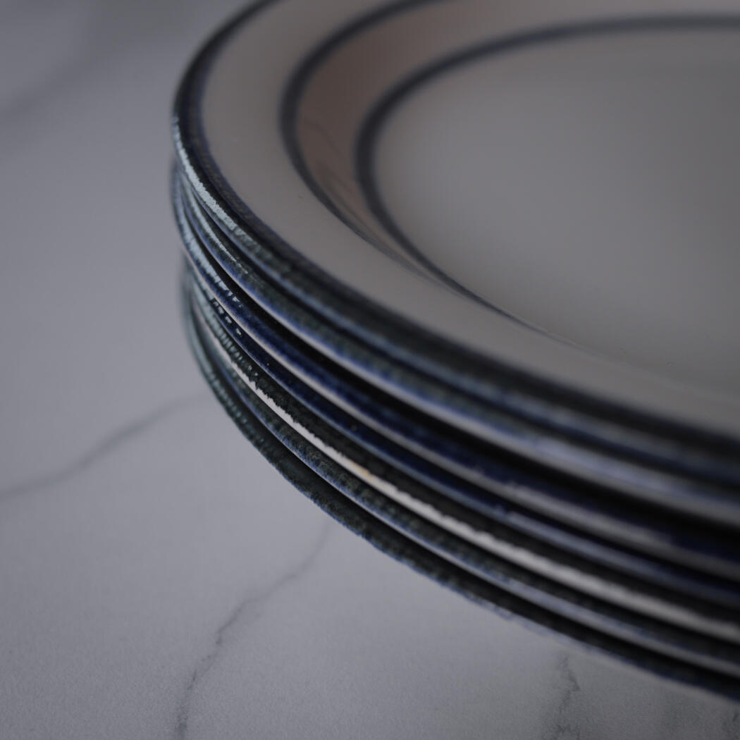 Close-up of stacked dark metal film reels on a pale marble surface.