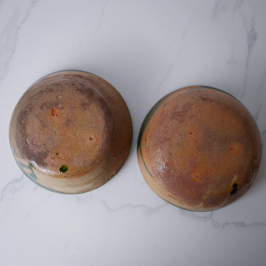 Two round loaves of crusty bread on a white marble surface, viewed from above.